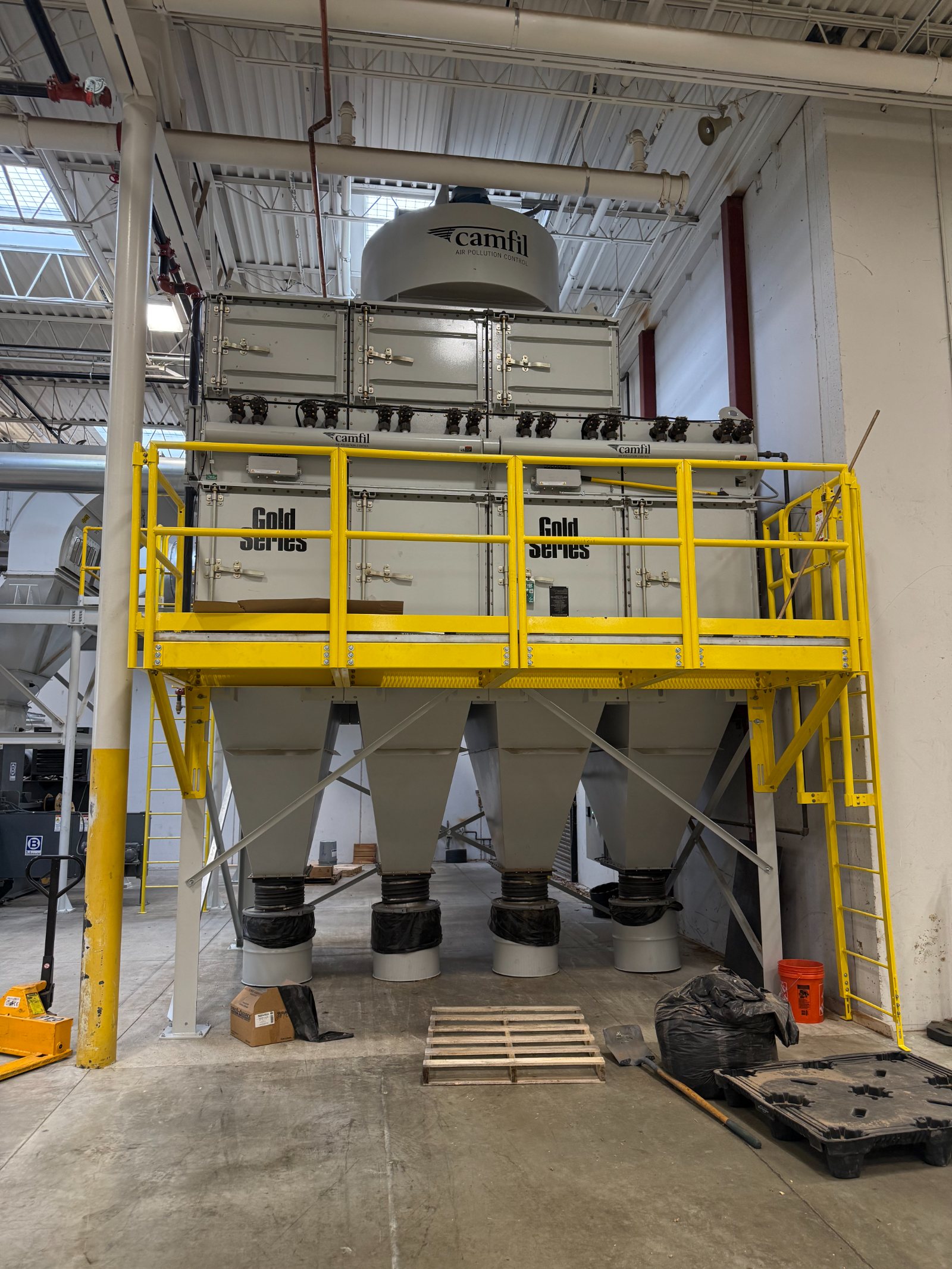 The Camfil Gold Series cartridge dust collector with yellow service platform and collection hoppers